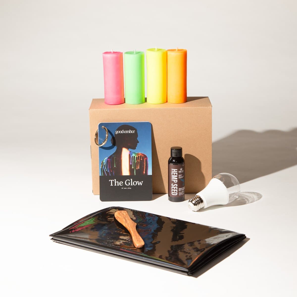 The Glow kit: UV wax play candles, hemp seed oil and drop sheet with the box.