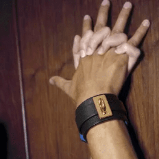 A hand holding a leather cuff.