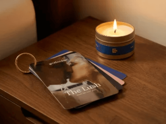 A lit massage candle and guidance booklet on a bedside table.
